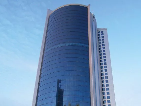 The iconic Bahrain Financial Harbour, a striking example of modern architecture with its twin towers soaring into a blue, cloud-dotted sky—home to prestigious Servcorp serviced offices,