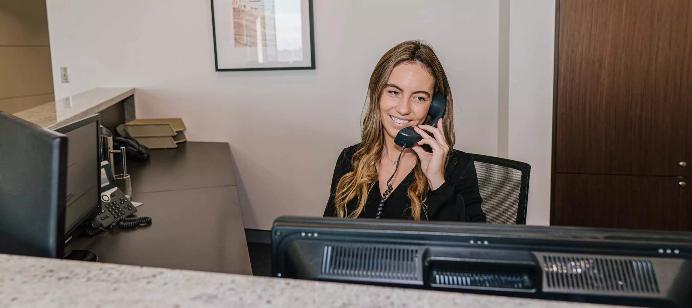  A receptionist answering calls at a professional front desk at Servcorp 