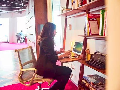  professional working at a stylish desk within a creative, open-plan environment—ideal for a virtual office setup at Servcorp, offering flexibility and a prestigious business presence.