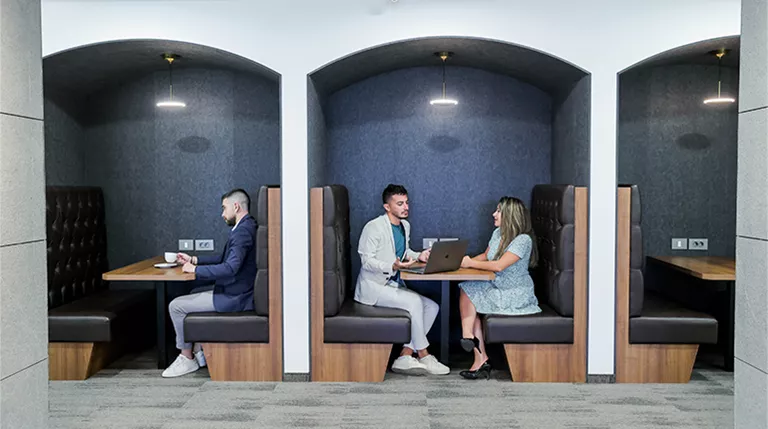 Coworking Space at Qubic Square with clients working and collaborating in an open hot desk area.